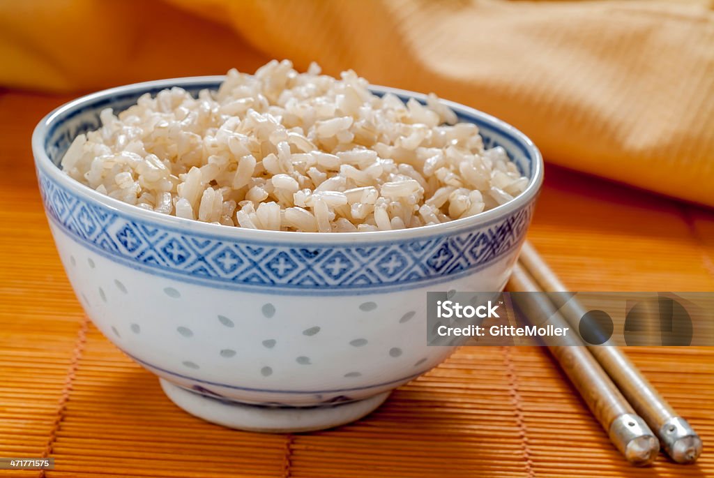 Brown rice in blue and white pattern bowl Brown rice in a blue and white rice pattern bowl with chopsticks. Blue Stock Photo