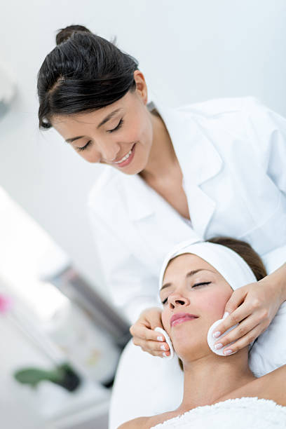 donna che lavora presso la spa - massaging facial massage beautician beauty treatment foto e immagini stock