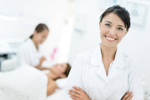 felice dermatologo presso la sua clinica - massaging facial massage beautician beauty treatment foto e immagini stock