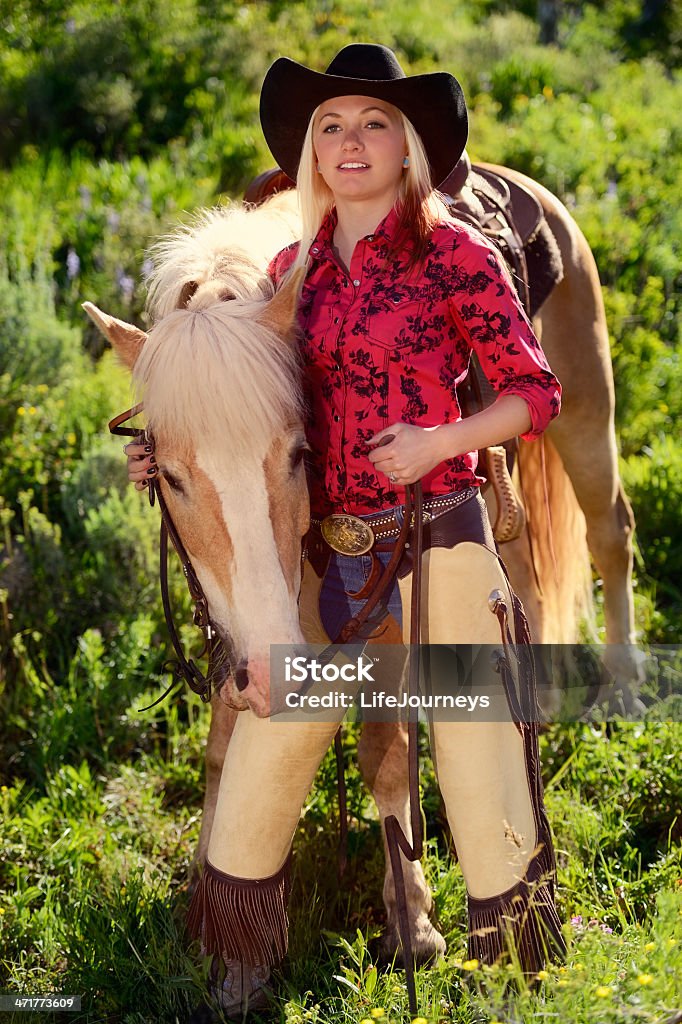 Pretty Ковбой-девушка с ее Паломино лошадь стоя в луг - Стоковые фото Ковбой-девушка роялти-фри