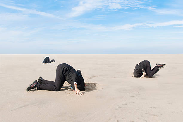 Business men hiding head in sand Three business men, hiding their heads in the sand. XXL size image. Image taken with Canon EOS 1 Ds Mark II and EF 17-35 mm 2,8 USM L. head in the sand stock pictures, royalty-free photos & images