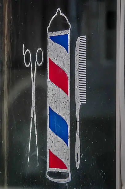scissors, hair comb and barber sign etched on window