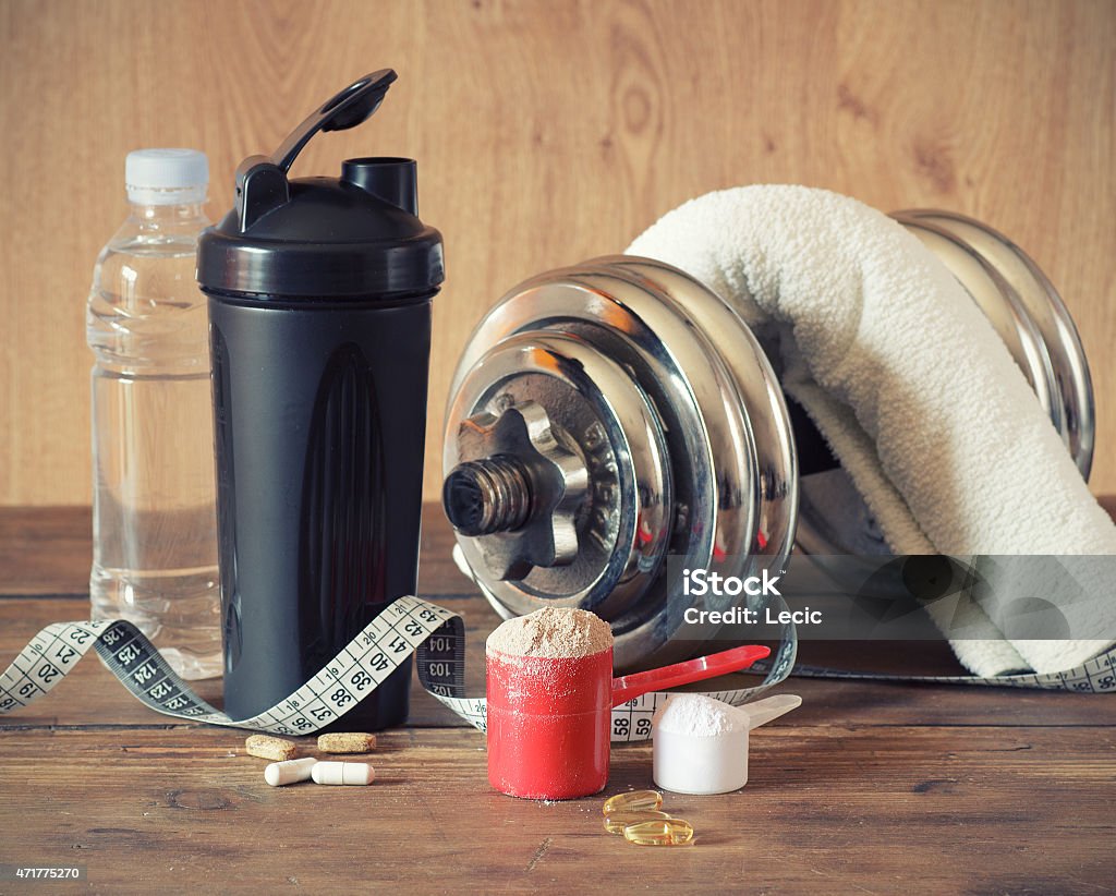 Whey protein powder Whey protein powder in scoop with vitamins and plastic shaker on wooden background Loss Stock Photo