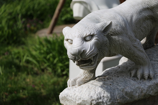 Marble statue of a jaguar in the park.