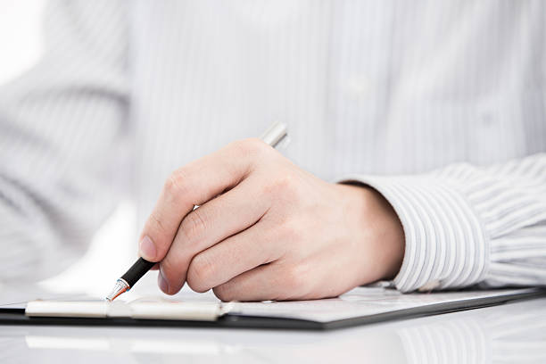 istock man hand with pen and business report 471777135