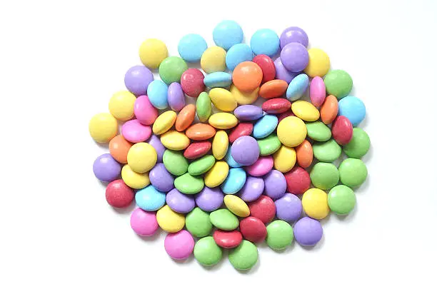 Isolated heap of colored smarties on white background