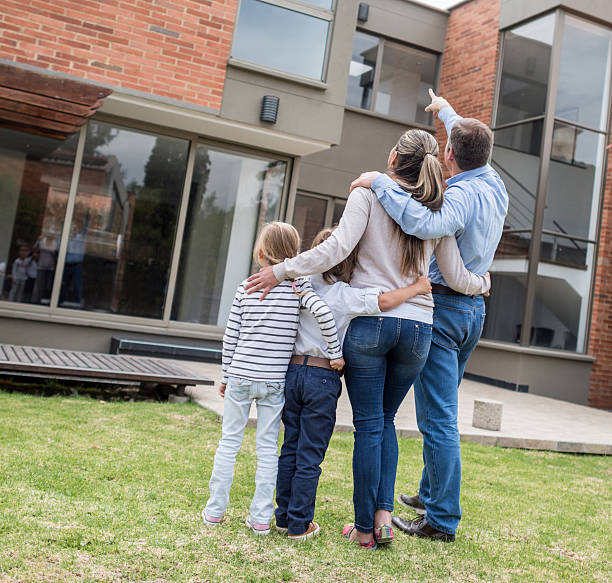 istock Family pointing at their house 471777980