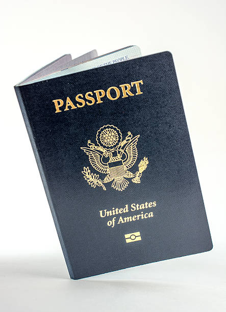United States passport open, slanted, and on light background stock photo