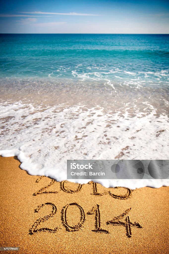 New year 2014 Sea waves erasing 2013 written in sand with 2014 on foreground 2013 Stock Photo
