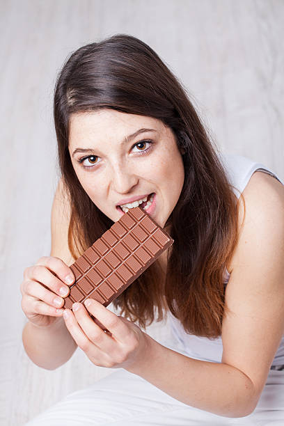 istock Pretty girl eating chocolate 471780465