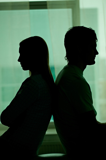 Silhouette of couple sitting back-to-back