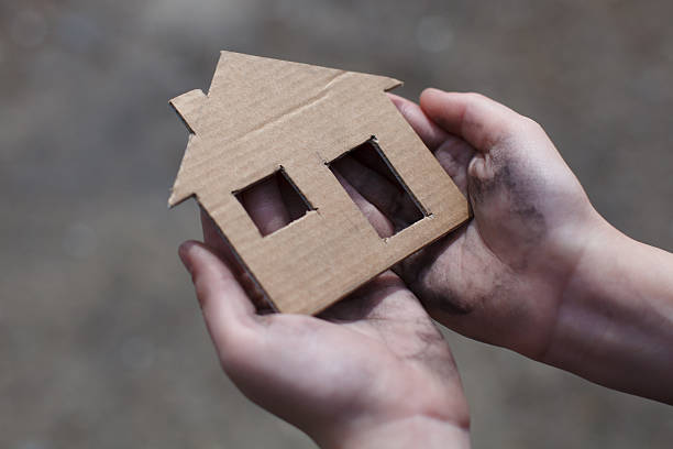 istock homeless boy holding a cardboard house 471782182