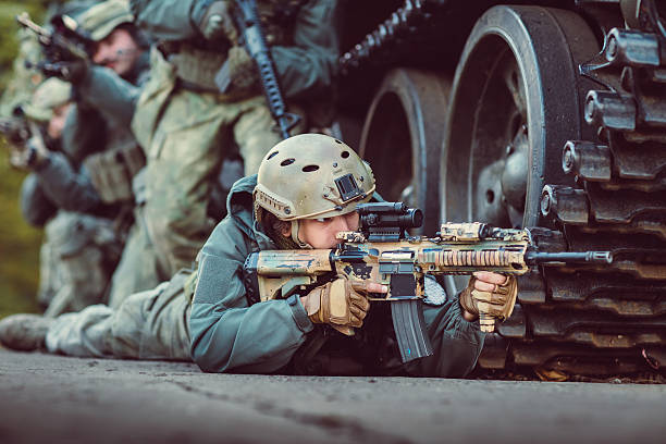 istock A soldier aiming his weapon and hiding by a tank 471782242
