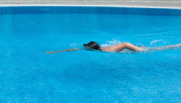 istock Boy is swimming in a pool. Side view. 471782337