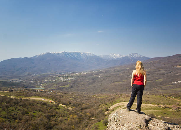 istock girl standing on a cliff in the mountains 471782724