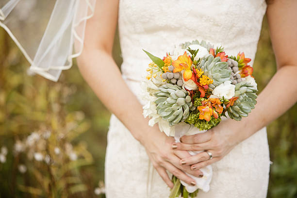 istock Bride holding wedding bouquet with Echeveria, Dahlia, and mini Hydrangea 471782994