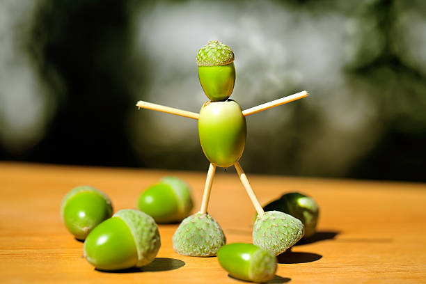 istock Little man made of green acorns 471783227