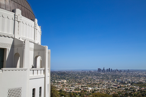 Griffith observatory in a beautiful blue sky day with Los Angeles downtown on the background.