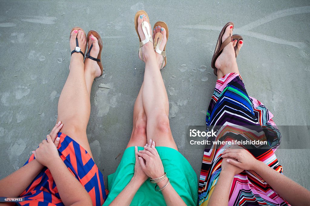 Füße und Beine von drei Freunde sitzen am Strand - Lizenzfrei Drei Personen Stock-Foto