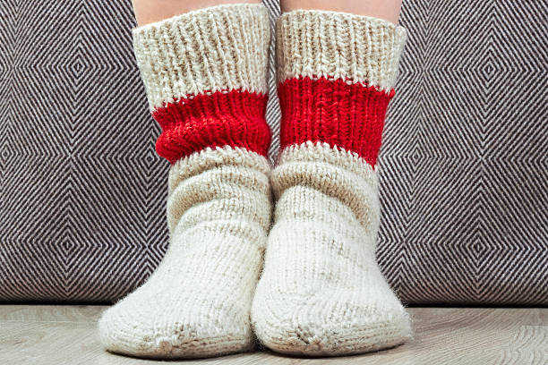 istock closeup  legs with pair wool knitted socks. Green grass behind 471784444
