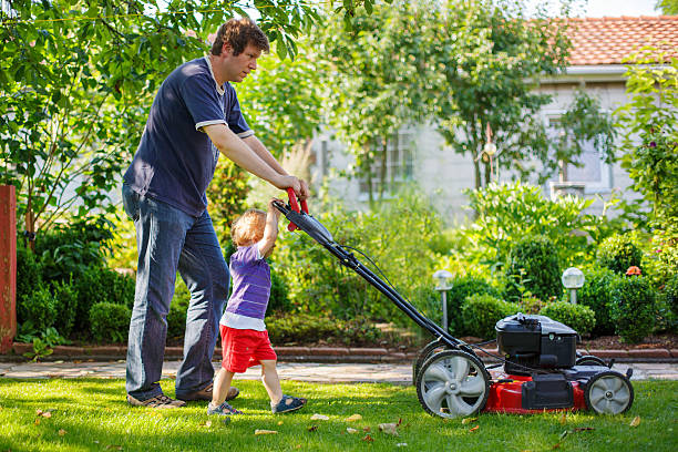 istock Father and son mowing the lawn together on a sunny day 471785865