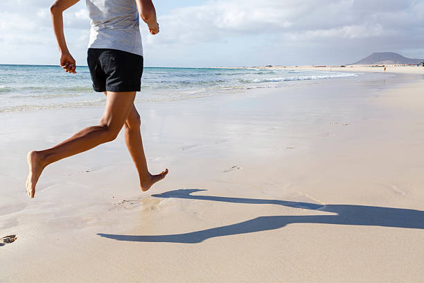 Woman running on beach Fit Asian runner jogging on beach barefoot Barefoot stock pictures, royalty-free photos & images