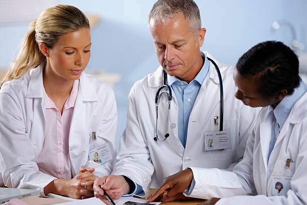 istock Team Of Medical Doctors Reviewing Notes/ Scans 471787281