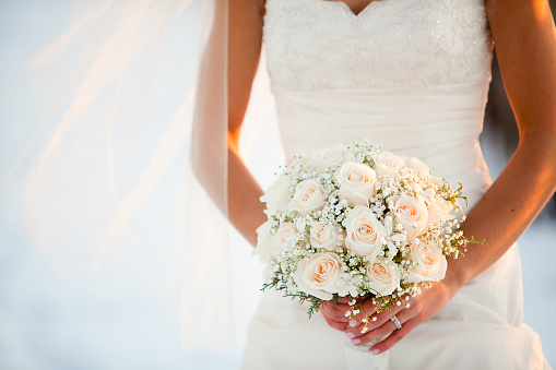 Bride holding wedding bouquet with Roses and BabyÕs breath flowers