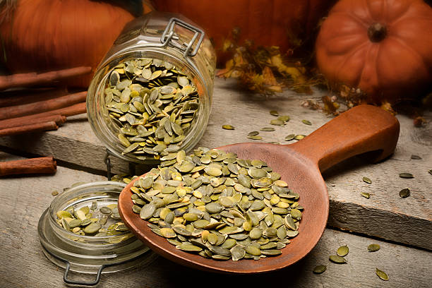 Raw and roasted pumpkin seeds stock photo