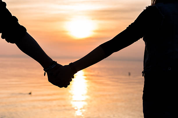 istock Bride and groom holding hands in front of a sunset 471789354