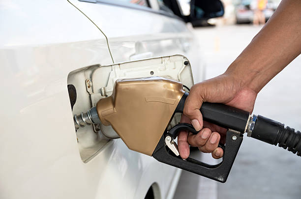 les hommes accumulent le plein d'essence pompe à essence pour ajouter le carburant en voiture - gasoline gas station labeling fuel and power generation photos et images de collection