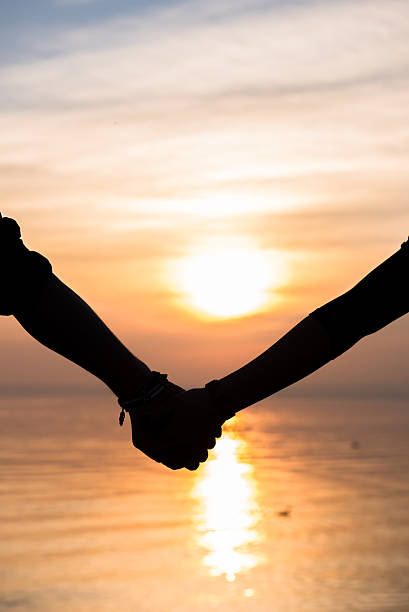 istock Bride and groom holding hands in front of a sunset 471789538