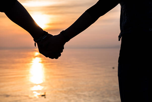 istock Bride and groom holding hands in front of a sunset 471789542