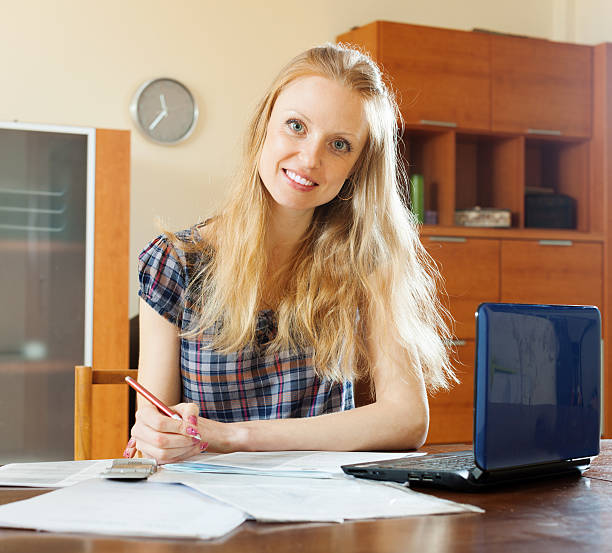 istock woman reading financial document at table 471790371