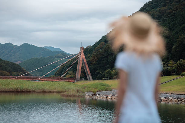 여자아이 부러워합니다 at 현수교 의 동틀 무렵. 스톡 사진