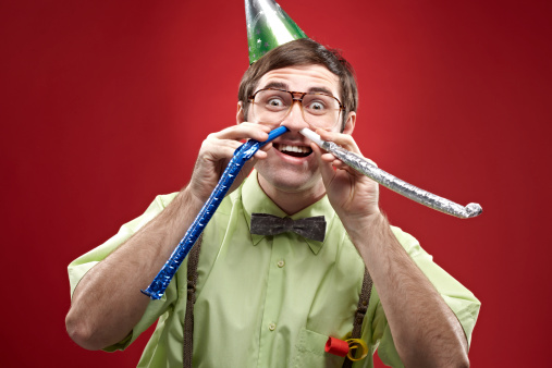 Excited crazy nerd, party horn blowers in his nostrils