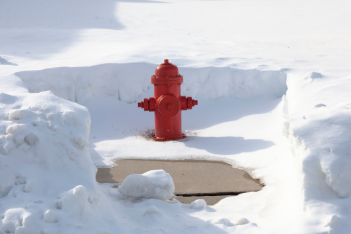 Snow cleared red fire hydrant. Community service oriented. Hydrants are cleared after a large snow storm. Vibrant red color against the white and blue and gray of the snow. Good for cropping or copy placement. XXXL size.