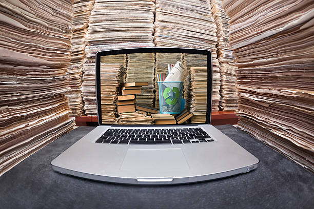 computador portátil entre enorme pilha de documentos com livros no ecrã - book stack embracing business imagens e fotografias de stock