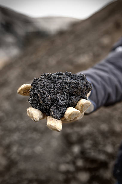 Handful of Oil Sand A handful of black oil rich sand from Alberta Canada. oilsands stock pictures, royalty-free photos & images