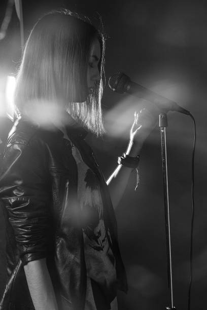 istock girl singing into a microphone in a studio 471795626