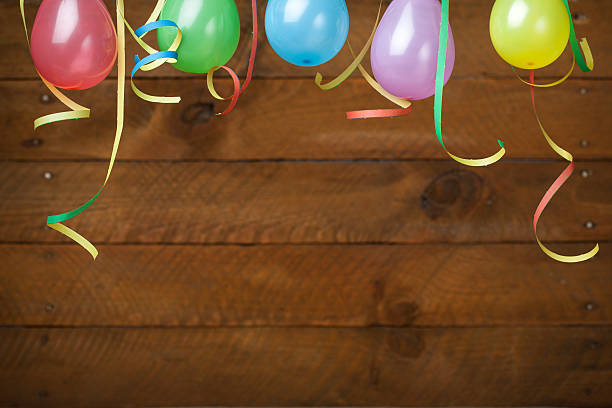 Balloons and Streamers against Wooden Background stock photo