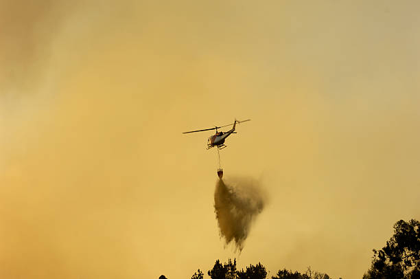 istock Helicopter Dropping Water on Out of Control Wildfire 471799723