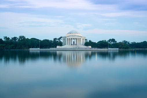 The Jefferson memorial as seen from across the tital basin. A long shutter exposure blurs the water in the foreground giving it a silky texture. 