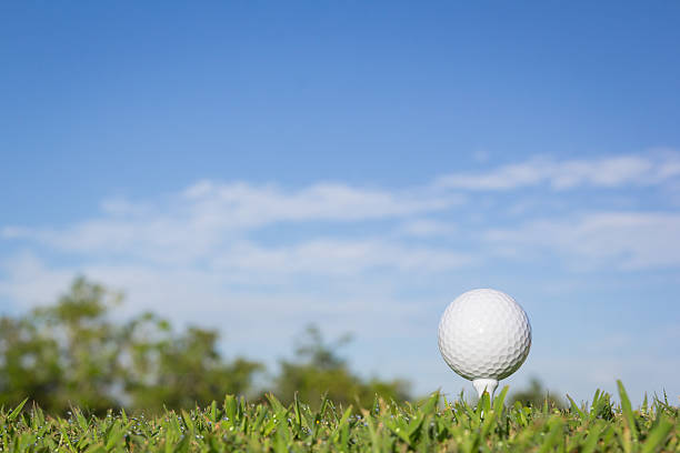 istock Golf ball on a tee with sky background 471800350