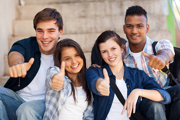 школа студентов, давать большие пальцы вверх - thumbs up teenager adolescence group of people стоковые фото и изображения