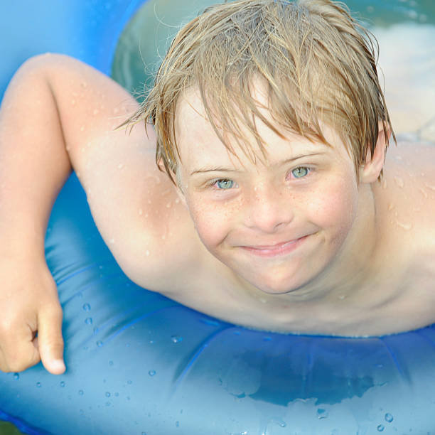 menino com bóia de pneu - swimming tube inflatable circle - fotografias e filmes do acervo