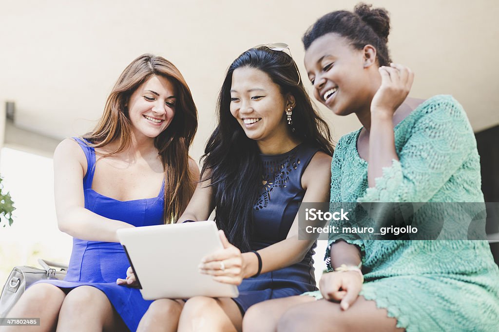 Trois jeunes femmes à l'aide d'une tablette numérique - Photo de 18-19 ans libre de droits