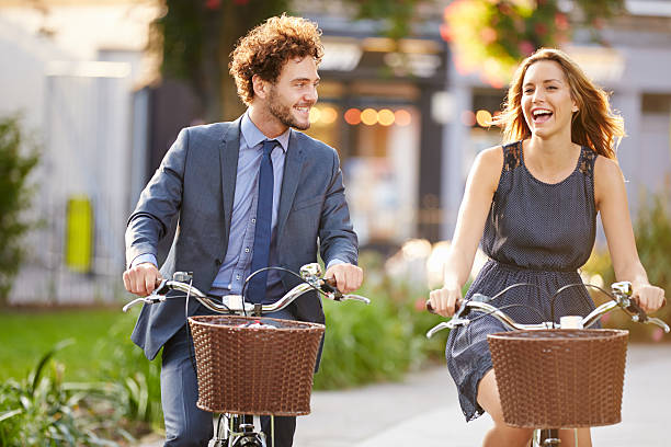 istock Couple in business clothes riding bicycles 471802934