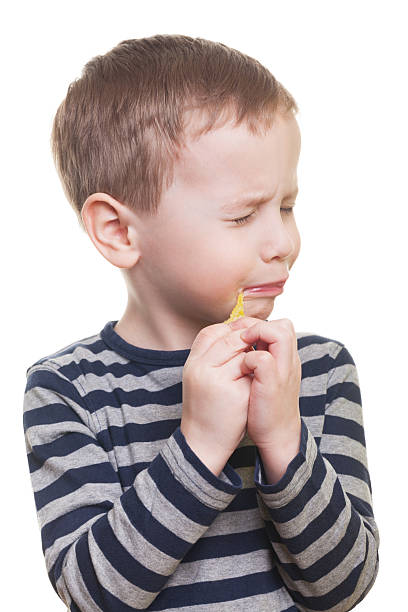 Sour candy Cute boy eating sour candy on isolated white sour face stock pictures, royalty-free photos & images