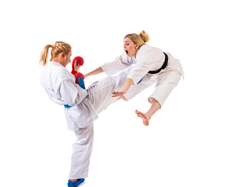Two woman practicing karate at isolated white background, 